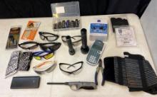 Seven pairs of sunglasses/safety glasses, bandannas, lighters, battery, bank, lens, wipes, bit