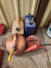 vintage metal gas can and 3 five gallon gas jugs