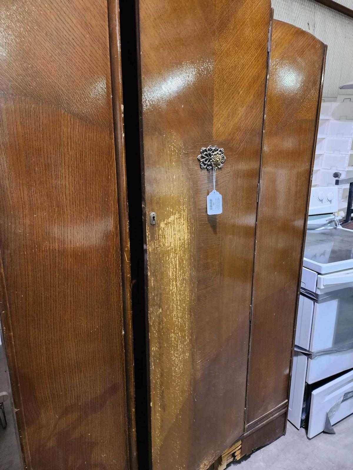 Large wood veneer armoire. Used, damaged base. 46" x 76" x 19".