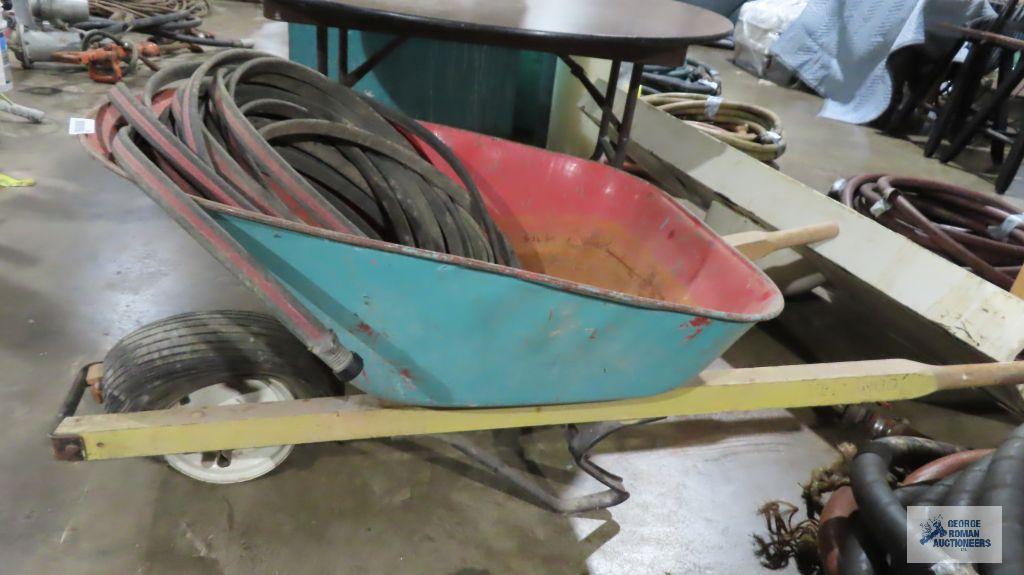 Wheelbarrow with pneumatic tire and soaker hose. Tire is flat
