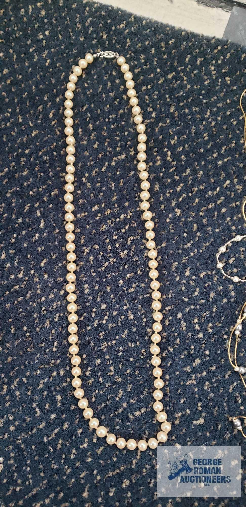 Pearl like costume jewelry in clear plastic divided container