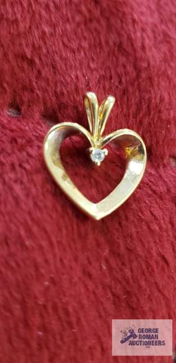 Gold colored heart-shaped pendant with clear gemstone, approximate total weight is 1.14 G