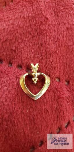 Gold colored heart-shaped pendant with clear gemstone, approximate total weight is 1.14 G