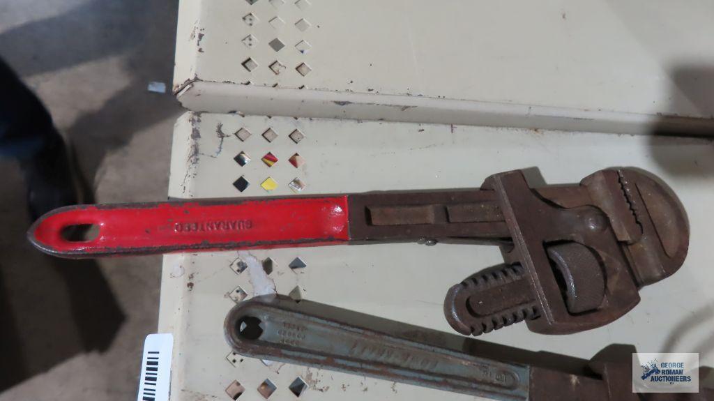 Pipe wrenches, measuring tape, and square
