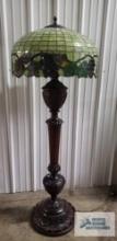 Antique wooden carved floor lamp with antique leaded glass shade with grape motif. 67 in tall. Base