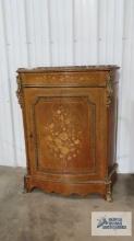 Antique marble top cabinet with floral motif and metal work. 43-1/2 in. tall by 35 in. long by
