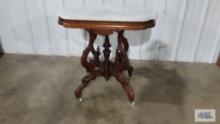 Victorian marble top table with porcelain wheels. 29-1/2 in. tall by 31 in. long by 20-1/2 in. wide