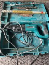 Makita model HR2455, rotary hammer, turned on, with assorted bits & case