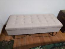 (BR2) CREAM UPHOLSTERED LIFT TOP STORAGE BENCH WITH BUTTON TUFTED TOP. SITTING IN WOODEN LEGS. IT