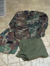 (BR2) BAG LOT OF ASSORTED MILITARY FATIGUES. INCLUDES: AMERICAN APPAREL CO. HOT WEATHER WOODLAND
