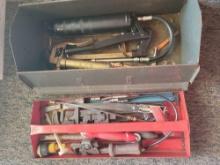 Metal tool box of pipe wrenches, grease gun and hack saw