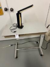 Lowering hospital table with lamp