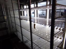 Row of White Shelving Just Inside Glass Doors of Walk In Cooler with Plasti