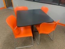 (1) black pedestal dining table with (4) orange chairs